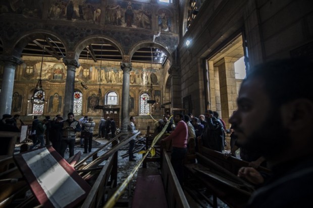 Egyptian security forces (L) inspect the scene of a bomb explosion at the Saint Peter and Saint Paul Coptic Orthodox Church on December 11, 2016, in Cairo's Abbasiya neighbourhood. The blast killed at least 25 worshippers during Sunday mass inside the Cairo church near the seat of the Coptic pope who heads Egypt's Christian minority, state media said. / AFP PHOTO / KHALED DESOUKI