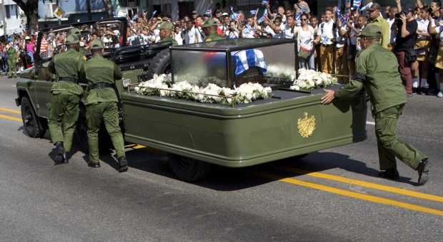 Soldiers push the jeep and trailer carrying the ashes of the late Fidel Castro after the jeep briefly stopped working during Castro's funeral procession near Moncada Fort in Santiago, Cuba, Saturday, Dec. 3, 2016. Castro's ashes will be interred Sunday in Santiago, ending a nine-day period of mourning that saw Cuba fall silent as thousands paid tribute to photographs of Castro and sign oaths of loyalty to his socialist, single-party system. (AP Photo/Rodrigo Abd)