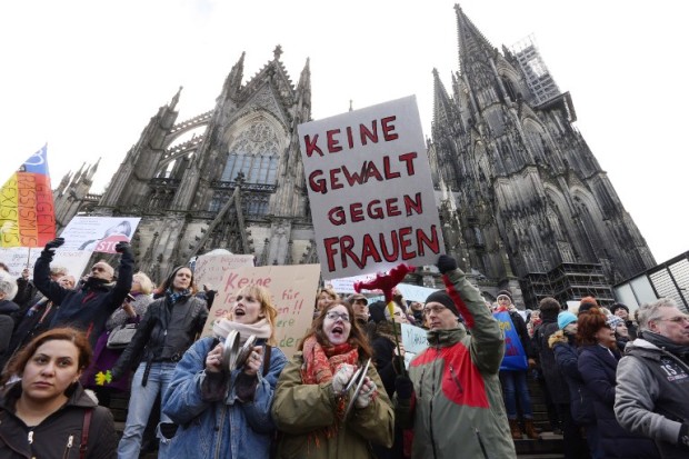 (FILES) This file photo taken on January 9, 2016 shows a man holding up a sign reading "No violence against women" as he takes part in a demonstration in front of the cathedral in Cologne, western Germany, where sexual assaults in a crowd of migrants took place on New Year's Eve. The German city of Cologne on December 12, 2016 announced a ramped-up police presence, more CCTV and a fireworks-free zone at upcoming New Year's Eve celebrations to avoid a repeat of last year's mass sexual assaults. Hundreds of women that night described being mugged and groped in a crowd of men of mainly Arab and north African appearance, incidents that shocked Germany and fuelled criticism of Chancellor Angela Merkel's liberal refugee policy. / AFP PHOTO / Roberto Pfeil