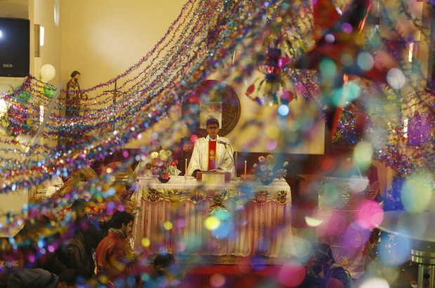 A priest conducts Christmas prayers at the holy family Catholic Church, in Srinagar, Indian controlled Kashmir, Sunday, Dec. 25, 2016. Christmas is a national holiday in India, marked by millions of all religions and faiths. (AP Photo/Mukhtar Khan)