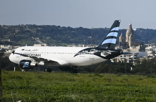 An Afriqiyah Airways plane from Libya stands on the tarmac at Malta's Luqa International airport, Friday, Dec. 23, 2016. Malta's state television says two hijackers who diverted a Libyan commercial plane to the Mediterranean island nation have threatened to blow it up. (AP Photo/Jonathan Borg)