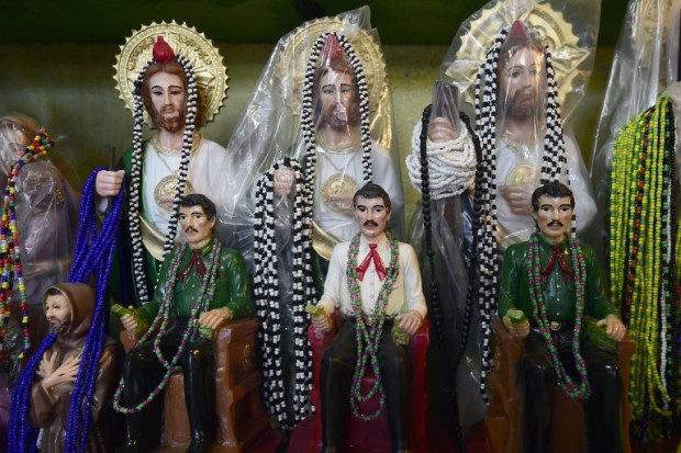 Images of narco-saint Jesus Malverde, who according to legend was a Robin Hood-type bandit who stole from the rich and gave to the poor, seen in the Malverde chapel in Culiacan, Sinaloa state in northwest Mexico, on December 7, 2016. On December 11, 2016 Mexico marked 10 years since the government began to deploy troops in a drug war that has killed tens of thousands of people, with many victims buried unceremoniously in mass graves, dumped on roadsides or left hanging on bridges. But the drug barons of Sinaloa state have given themselves more dignified final resting places: two-story tombs fitted with living rooms, air conditioning and bulletproof glass. / AFP PHOTO / ALFREDO ESTRELLA / TO GO WITH AFP STORY BY LAURENT THOMET