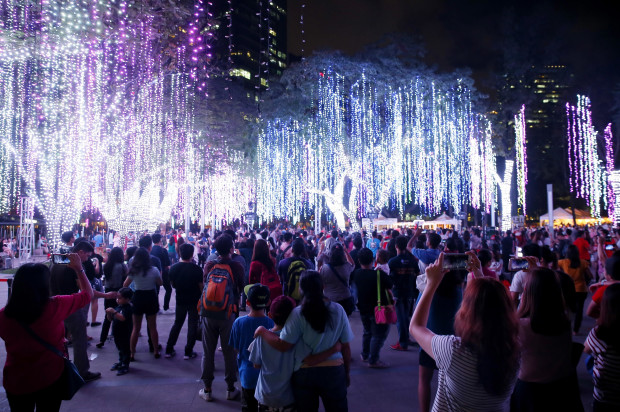 People take photos of the "Christmas and Light" show Friday, Dec. 16, 2016, at the financial district of Makati city east of Manila, Philippines. The "dancing" lights and laser show, which boasts of over a million Christmas lights, has attracted thousands of Filipinos every Yuletide season. (AP Photo/Bullit Marquez)