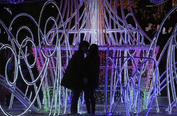 A kissing couple is silhouetted against illuminations celebrating the Christmas and New Year holiday season at Ilsan Lake Park in Goyang, South Korea, Sunday, Dec. 25, 2016. (AP Photo/Ahn Young-joon)