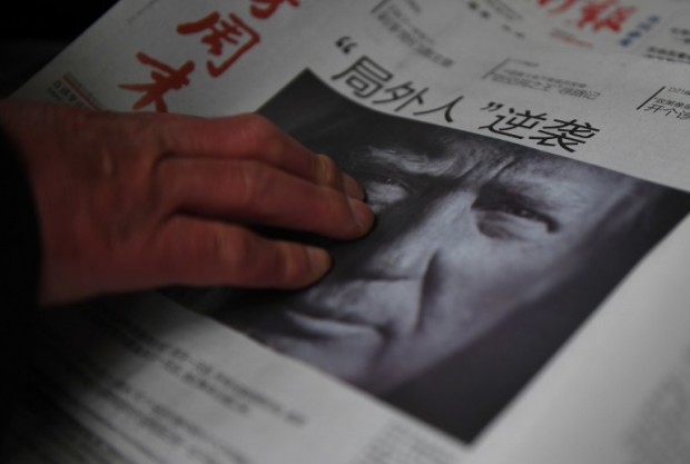 (FILES) This file photo taken on November 10, 2016 shows a man buying a newspaper featuring a photo of US President-elect Donald Trump, the day after the US election, at a news stand in Beijing on November 10, 2016.   The headline reads "Outsider strikes back".  President-elect Donald Trump broke with decades of cautious US diplomacy on December 2 to speak with the president of Taiwan, at the risk of provoking a serious rift with China. / AFP PHOTO / GREG BAKER