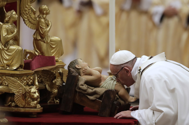 Pope Francis kisses a statue of Baby Jesus as he celebrates the Christmas Eve Mass in St. Peter's Basilica at the Vatican, Saturday, Dec. 24, 2016. (AP Photo/Alessandra Tarantino)