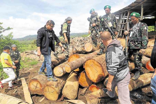 Environment officials inspect logs and forest products seized during raids in a Lanao del Sur town. —CONTRIBUTED PHOTO