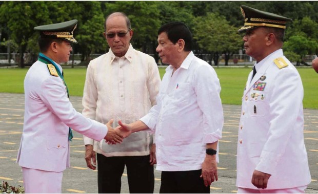 CHANGE OFCOMMAND President Duterte congratulates incoming Armed Forces of the Philippines Chief of Staff Lt. Gen. Eduardo Año at the AFP change of command ceremony at Camp Aguinaldo on Wednesday. Looking on are Defense Secretary Delfin Lorenzana (left) and outgoing AFP Chief Gen. Ricardo Visaya. —GRIG C.MONTEGRANDE 