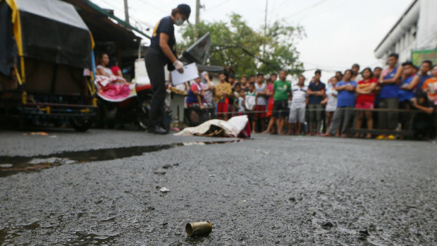An empty shell of a pistol lies near the body of a woman, later identified by her husband as that of Nora Acielo, after she was shot by still unidentified men while about to bring her two children to school at a poor neighborhood in Manila, Philippines, Thursday, Dec. 8, 2016. Police said the killing of Acielo was the 13th recorded drug-related case in the past 24 hours in President Rodrigo Duterte's unrelenting war on drugs. (AP Photo/Bullit Marquez)