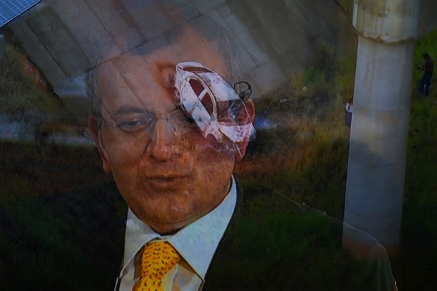 Picture of a TV set taken while TV Globo News shows the car and the face of Greek ambassador in Brazil, Kyriakos Amiridis in Nova Iguacu, Baixada Fluminense, Rio de Janeiro on December 30, 2016.  The car was found burned by police, under a bridge with an unidentified corpse inside. / AFP PHOTO / VANDERLEI ALMEIDA / Brazil OUT / BRAZIL OUT