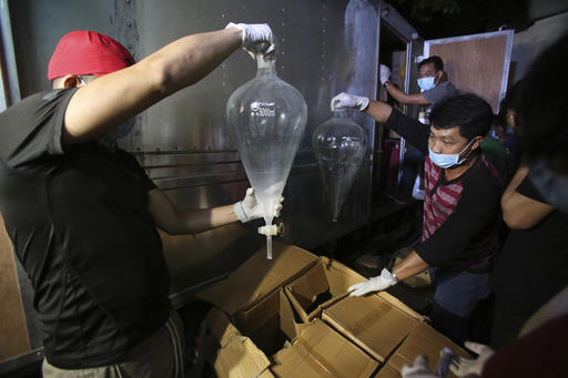 Members of the National Bureau of Investigation look at laboratory materials used to manufacture Methamphetamine, locally known as Shabu, that was seized from a truck that was parked inside a house of suspects in San Juan, east of Manila, Philippines on Friday, Dec. 23, 2016. Philippine authorities say they have arrested six people in what could be one of the largest drug seizures under President Rodrigo Duterte. (AP Photo/Aaron Favila)