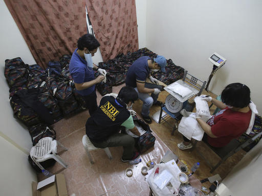 Operatives of the National Bureau of Investigation inspect suspected Methamphetamine, locally known as Shabu, weighing more or less 500 kilos that was seized from two still unidentified Chinese nationals at their home in San Juan, east of Manila, Philippines on Friday, Dec. 23, 2016. Philippine authorities say they have arrested six people in what could be one of the largest drug seizures under President Rodrigo Duterte. (AP Photo/Aaron Favila)