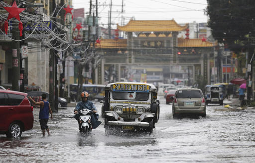 A passenger jeep navigates a flooded street caused by rains from Typhoon Nina (Nock-Ten) in Quezon City on Monday, Dec. 26, 2016. The powerful typhoon slammed into the eastern Philippines on Christmas Day, spoiling the biggest holiday in Asia's largest Catholic nation, where a governor offered roast pig to entice villagers to abandon family celebrations for emergency shelters. (AP Photo/Aaron Favila)