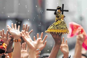 BLESSING RITES A priest sprinkles holy water over replicas of the Black Nazarene image. Millions are expected to show up in today’s “traslacion” when the image is brought from Rizal Park to Quiapo Church in Manila. —LEO M. SABANGAN