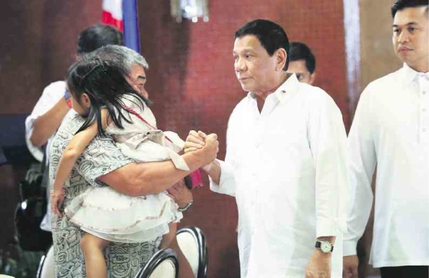 REMEMBERING BRAVE TROOPERS President Duterte meets with the families of the 44 slain elite police commandos in Maguindanao province during a dialogue on Tuesday in Malacañang. In photo, he greets relatives of Senior Insp. Ryan Pabalinas, and daughter Camille. —JOAN BONDOC