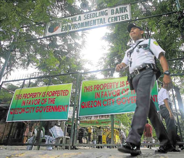 A guard secures the gated area used by Manila Seedling Bank Foundation, in this file photo taken on July 10, 2012, after the property was seized by the Quezon City government.—MARIANNE BERMUDEZ