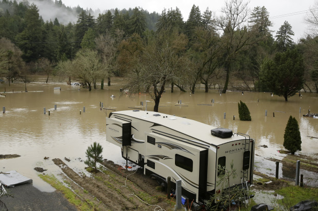 Water from the Russian River floods an RV park Monday, Jan. 9, 2017, near Forestville, Calif. A massive storm system stretching from California into Nevada lifted rivers climbing out of their banks, flooded vineyards and forced people to evacuate after warnings that hillsides parched by wildfires could give way to mudslides. (AP Photo/Eric Risberg)