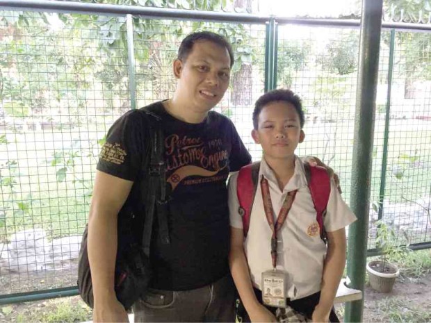 COPING Benjie Sarreal, together with his 11-year- old son Bienwho is deaf, smiles for the camera after sharing how he now struggles without hiswife Arlene by his side. 