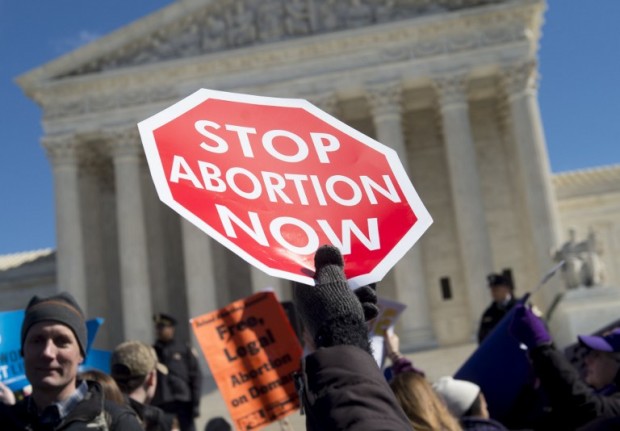 Anti-abortion activists rally outside of the Supreme Court in Washington, DC, March 2, 2016, following oral arguments in the case of Whole Woman's Health v. Hellerstedt, which deals with access to abortion in Texas. The US Supreme Court on March 2 took up its most important abortion case in a generation, the outcome of which could impact the ability of millions of women to end an unwanted pregnancy -- as well as the White House race. With the court now split evenly between liberals and conservatives following the death of Antonin Scalia, all eyes are on Justice Anthony Kennedy, who wields a swing vote on the issue, one of the most divisive in the world of US politics.  / AFP PHOTO / SAUL LOEB