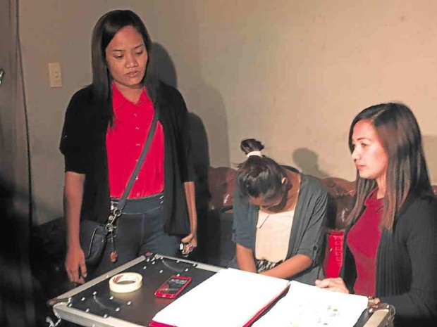 The drug-peddling suspect (center) is presented on Friday by her “buyers” SPO1 Marivel Morte (standing) and PO1 Freda Bumasao of the Taguig police.