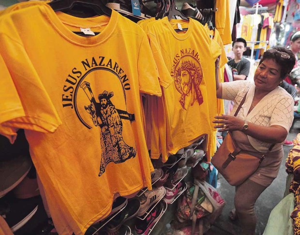 BUSINESS SENSE Lisa Isangga, 62, enjoys brisk sales of T-shirts every Feast of the Black Nazarene in Quiapo, Manila. The shirts are sold for P150 apiece.  GRIG C.MONTEGRANDE