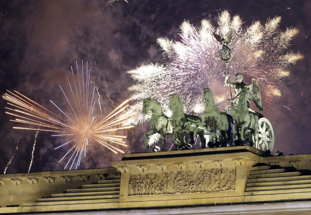 Fireworks light the sky above the Quadriga at the Brandenburg Gate shortly after midnight in Berlin, Germany, Sunday, Jan. 1, 2017. Hundred thousands of people celebrated New Year's Eve welcoming the new year 2017 in Germany's capital. (AP Photo/Michael Sohn)