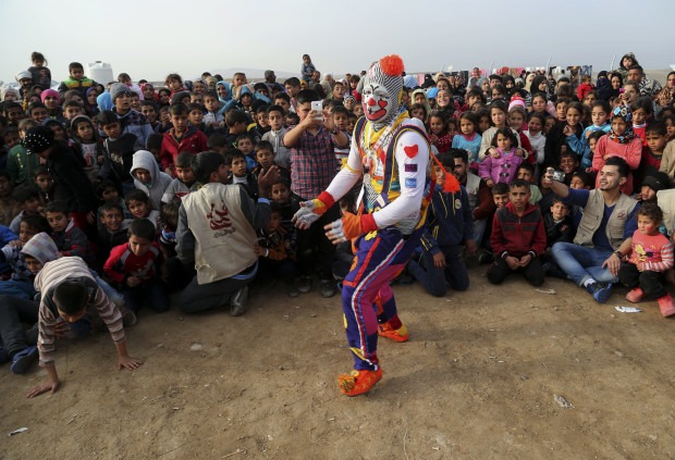 A clown performs during a New Year's celebration for internally displaced children at the Hassan Sham camp, east of Mosul, Iraq, Saturday, Dec 31, 2016. (AP Photo/ Khalid Mohammed)