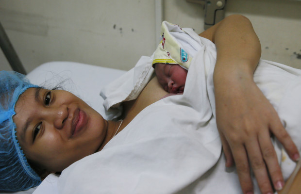 CORRECTS PRESIDENT'S NAME AND NAME OF HOSPITAL - Baby Shammah Jane Bolon sleeps in her mother Mary Rose's arms in the recovery room of the Dr. Jose Fabella Memorial Hospital after being born at exactly 12:00 midnight to become the first baby born on New Year Sunday, Jan. 1, 2017 in Manila, Philippines. The country's notorious tradition of dangerous New Year's Eve celebrations persisted after President Rodrigo Duterte delayed to next year his ban on the use of powerful firecrackers, often worsened by celebratory gunfire. (AP Photo/Bullit Marquez)