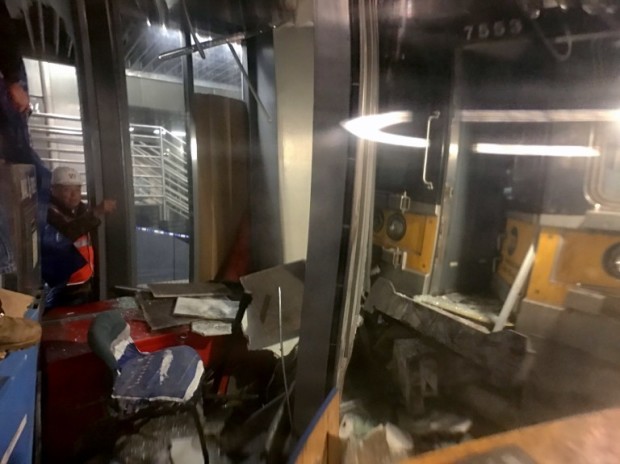 Viewed through the window, workers are on the scene where a commuter train derailed at the Atlantic Terminal in Brooklyn, officials said on January 4, 2017. A commuter train derailed Wednesday at a station in Brooklyn and injured nearly 80 people, officials said, setting off a panic during the morning rush. The Long Island Rail Road train crashed around 8:30 am (1330 GMT) at Atlantic Terminal in the heart of the New York borough."76 non life-threatening injuries reported at scene of LIRR train derailment, Atlantic Terminal Brooklyn," the New York Fire Department said in a tweet. / AFP PHOTO / KENA BETANCUR