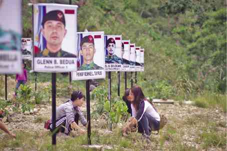 Relatives of SAF 44 men from the Cordillera plant banners for the officers in Badiwan Hobbitat in Tuba, Benguet province. —RICHARD BALONGLONG