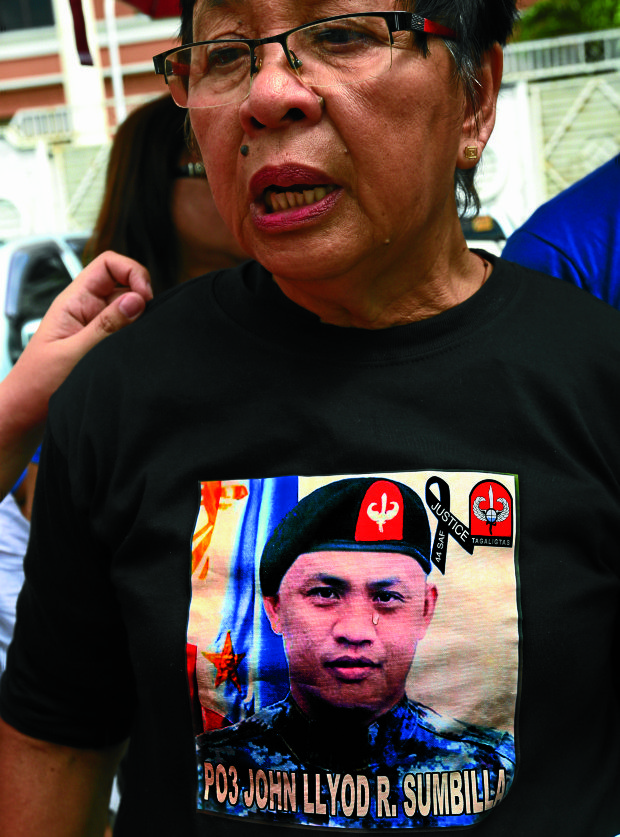 A tear shed by Telly Sumbilla, 64, falls on her shirt and onto the image of her son, PO3 John Lloyd Sumbilla, one of the 44 police commandos slain in the Mamasapano massacre two years ago. —EDWIN BACASMAS