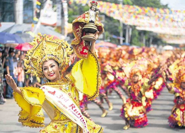 The Sinulog is all about Cebu province’s most revered religious icon, the Sto. Niño, represented by a replica being held by a participant in a dance competition in Cebu City. —LITO TECSON/CEBU DAILY NEWS