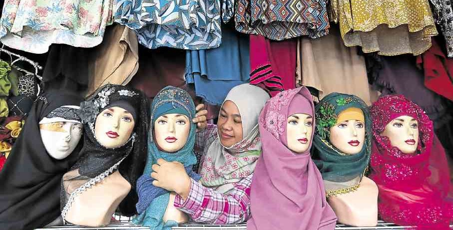 SCARF FASHION Amina Ameroding of Marawi City sells hijab at the Islamic Center in Quiapo, Manila, as Muslim communities celebrate World Hijab Day on Feb. 1. —MARIANNE BERMUDEZ