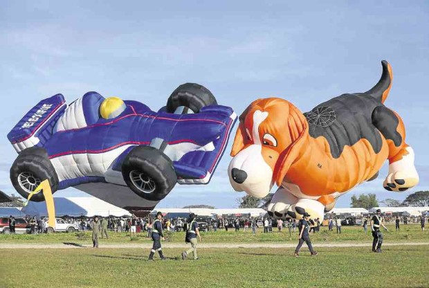 DOGS WILL BE DOGS A beagle balloon seems to be chasing a race car balloon at the Hot Air Balloon Festival at Clark Freeport in Pampanga. The balloon festival started in 1994. —LYN RILLON