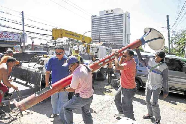 A team of workers in Cebu City dismantle one of the overpriced lampposts put up for the Asean Summit in 2007.  —JUNJIE MENDOZA/CEBU DAILY NEWS