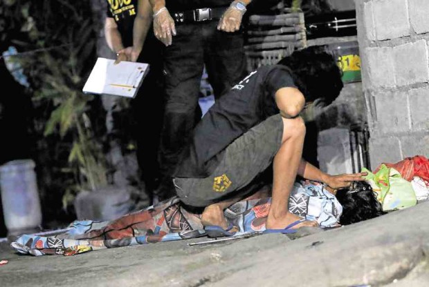 A family member caresses the slain Cristeta Ramos outside their Quezon City home early Saturday.—RICHARD A. REYES
