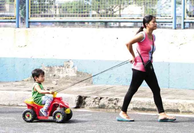 Proponents of the “family zones” project hope to see more residents having entire streets to themselves for rest and recreation, like this mother and her child in Pasig City.—LYN RILLON