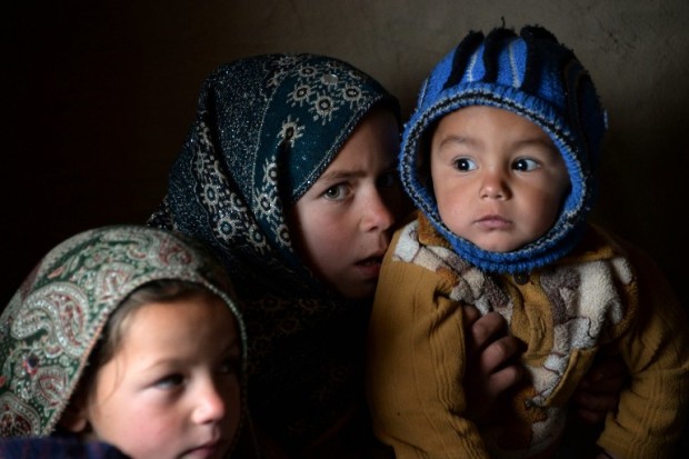 In this photograph taken on January 18, 2017, Afghan children warm themselves with a blanket inside a mud house at a refugee camp on the outskirts of Laghman. Marooned in a tent billowing in the winter wind, Gul Pari's family is among thousands of war-displaced Afghans crammed into settlements alongside a flood of returning refugees, in a double-pronged humanitarian crisis engulfing the country. Conflict-torn Afghanistan is struggling to reabsorb large masses of refugees and failed asylum seekers being sent back from Pakistan, Europe and Iran, joining more than half a million others uprooted by war. Photo from AFP.