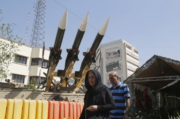 Iranians walk past Sam-6 missiles displayed in the street during a war exhibition to commemorate the 1980-88 Iran-Iraq war at Baharestan square, south of Tehran on September 26, 2016. / AFP PHOTO / ATTA KENARE