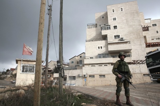 This photo taken on January 25, 2017 shows an Israeli soldier (R) standing guard in the Israeli settlement of Beit El near the West Bank city of Ramallah. Israel has moved immediately to take advantage of US President Donald Trump's pledges of support, announcing a major settlement expansion that deeply concerns those hoping to salvage a two-state solution with the Palestinians.  / AFP PHOTO / - / MENAHEM KAHANA