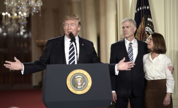 Judge Neil Gorsuch (C) and his wife Marie Louise look on, after US President Donald Trump nominated him for the Supreme Court, at the White House in Washington, DC, on January 31, 2017. President Donald Trump nominated federal appellate judge Neil Gorsuch as his Supreme Court nominee, tilting the balance of the court back in the conservatives' favor. / AFP PHOTO / Brendan SMIALOWSKI