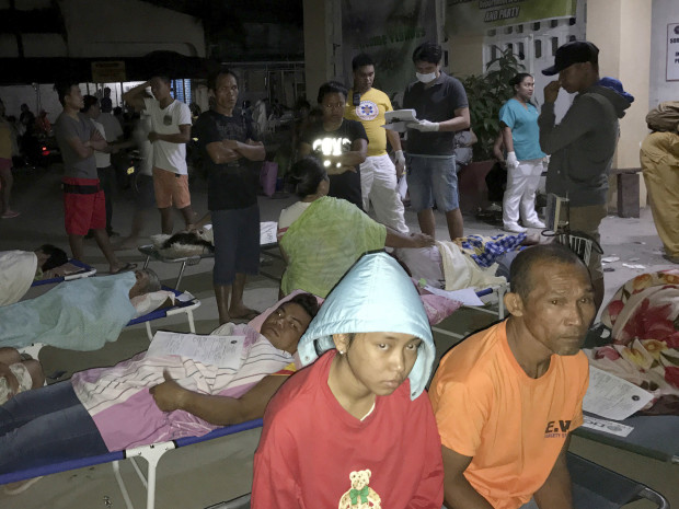 Patients spend the night outside a hospital after abandoning their rooms following a powerful earthquake that rocked Surigao city, Surigao del Norte province, in the southern Philippines, Saturday, Feb. 11, 2017. AP 
