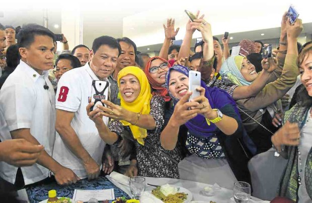 Supporters of President Duterte take selfies with him.  (MALACAÑANG PHOTO)