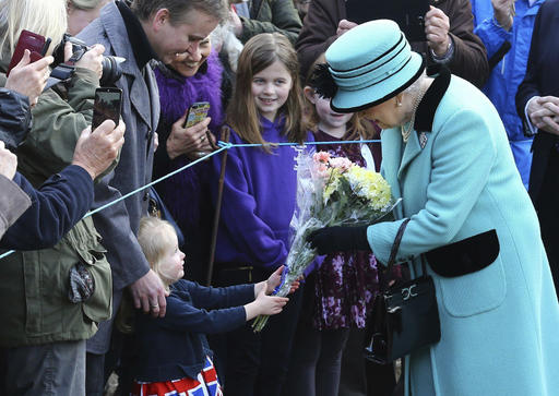 Britain's Queen Elizabeth II stops to receive flowers from 3-year old Jessica Atfield, after the queen and her husband Duke of Edinburgh, attended a church service at St Peter and St Paul church in West Newton, England, Sunday Feb. 5, 2017.  The Queen is to make history on Monday Feb. 6, when she becomes the first British monarch to reach the Sapphire Jubilee, marking the 65th. anniversary of her accession to the throne. (Gareth Fuller/PA via AP)