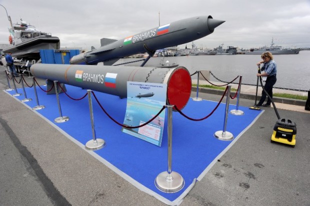 A woman cleans a carpet flooring close to a Brahmos supersonic cruise missile at the International Maritime Defence Show in St. Petersburg on July 2, 2015. AFP PHOTO / OLGA MALTSEVA / AFP PHOTO / OLGA MALTSEVA