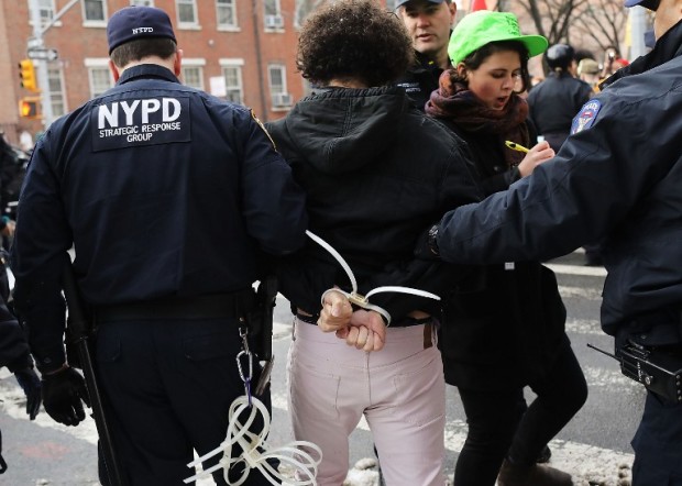 NEW YORK, NY - FEBRUARY 11: A demonstrator is arrested during a protest and march against the immigration polices of President Donald Trump and other issues on February 11, 2017 in New York City. Trump announced on Friday that he is considering rewriting his executive order temporarily barring refugees and citizens of seven Muslim-majority countries from entering the United States.   Spencer Platt/Getty Images/AFP