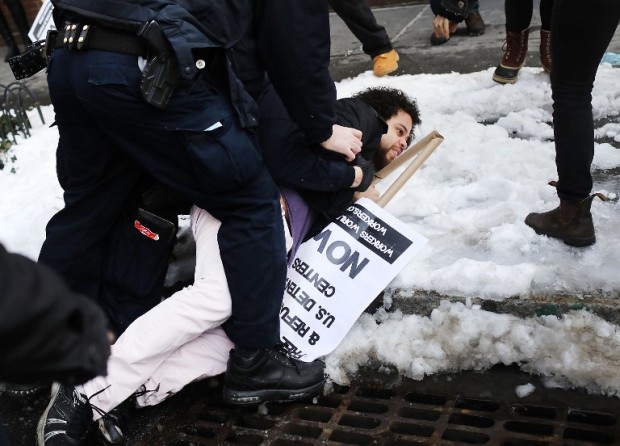 NEW YORK, NY - FEBRUARY 11: A demonstrator is arrested during a protest and march against the immigration polices of President Donald Trump and other issues on February 11, 2017 in New York City. Trump announced on Friday that he is considering rewriting his executive order temporarily barring refugees and citizens of seven Muslim-majority countries from entering the United States.   Spencer Platt/Getty Images/AFP