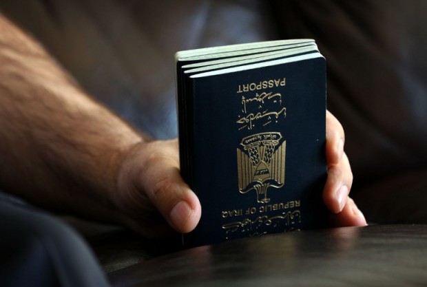 Fuad Sharif Suleman holds the passport of his family members in Arbil, the capital of the Kurdish autonomous region in northern Iraq, on January 30, 2017 after returning to Iraq from Egypt, where him and his family were prevented from boarding a plane to the US following US President Donald Trump's decision to temporarily bar travellers from seven countries, including Iraq.  / AFP PHOTO / SAFIN HAMED
