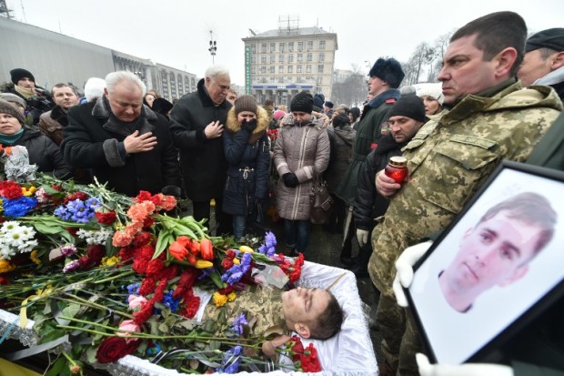 Relatives of one of the seven Ukrainian servicemen who died during fighting in eastern Ukrainian town of Avdiivka, in Donetsk region, react next to the coffin during a mourning ceremony on Independence Square in Kiev on February 1, 2017. The death toll from the latest escalation in fighting in Ukraine rose to 16 as international alarm rang out over the spike in bloodshed in the European Union's back yard. Government forces and pro-Russian separatists exchanged mortar and grenade fire for a fourth day around the flashpoint town of Avdiivka that sits just north of the rebels' de facto capital Donetsk in eastern Ukraine. / AFP PHOTO / Sergei SUPINSKY
