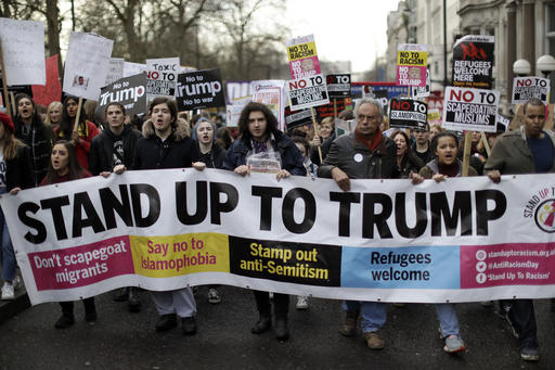 People hold a banner as they take part in a protest march in London, against U.S. President Donald Trump's ban on travellers and immigrants from seven predominantly Muslim countries entering the U.S., Saturday, Feb. 4, 2017. Thousands of protesters have marched on Parliament in London to demand that the British government withdraw its invitation to U.S. President Donald Trump. (AP Photo/Matt Dunham)